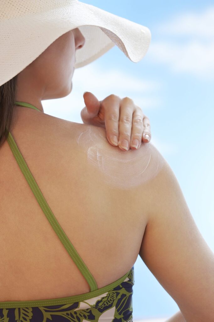 woman applying sunscreen that may be damaging her skin